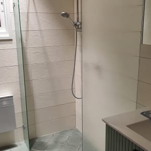 מקלחת עם ראש מקלחת ודלת זכוכית