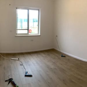 חדר עם פרקט עץ וכלי עבודה על הרצפה