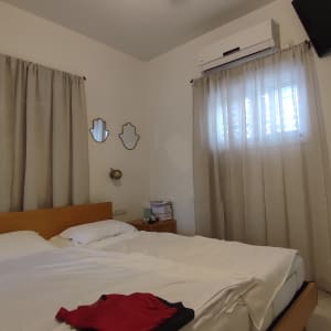 וילונות בהירים תלויים על חלונות בחדר שינה