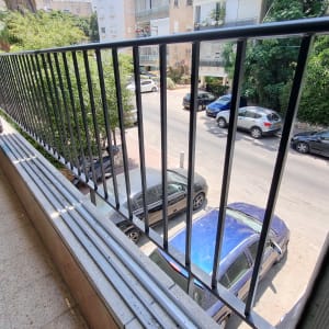 מעקה מתכת במרפסת עם נוף לרחוב