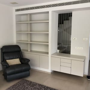 כורסה עם כרית על שטיח בחדר מגורים