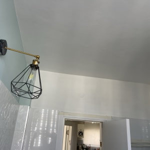 מנורה תלויה עם נורה על קיר צבוע