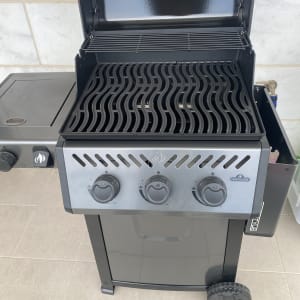 גריל גז עם שלושה כפתורי שליטה ומכסה פתוח