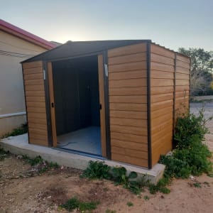 מחסן עץ עם דלתות פתוחות על משטח בטון