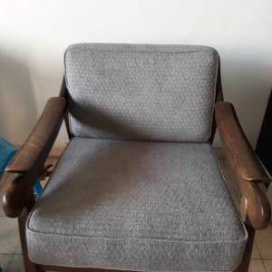 כיסא מרופד בבד אפור עם מסגרת עץ כהה