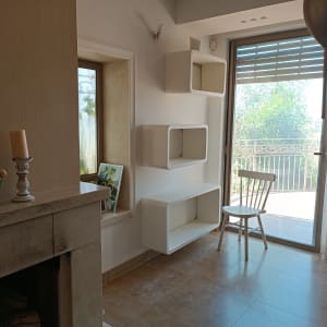 כיסא עץ ליד מדפים תלויים על הקיר