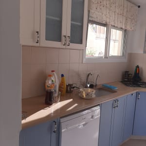 מטבח עם ארונות עץ ודלתות זכוכית