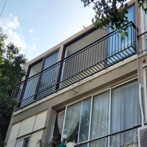 מעקה מתכת שחור על מרפסת בקומה עליונה