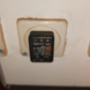 בודק שקע חשמלי מחובר לשקע בקיר