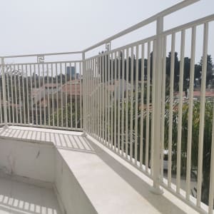 מעקה מתכת לבן על מרפסת עם רצפת אריחים