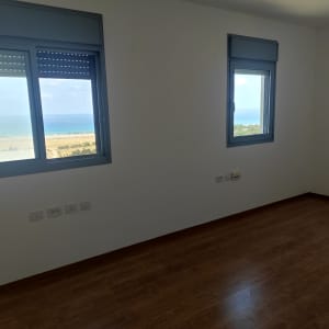 קירות לבנים וחלונות עם מסגרות כחולות