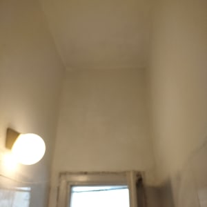 קיר צבוע בלבן עם מנורה עגולה