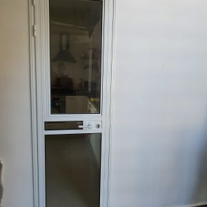 דלת אלומיניום עם זכוכית שקופה ומסגרת לבנה