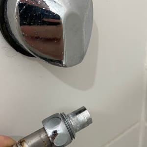 חיבור צינור מתכת ליד ידית כרום בקיר