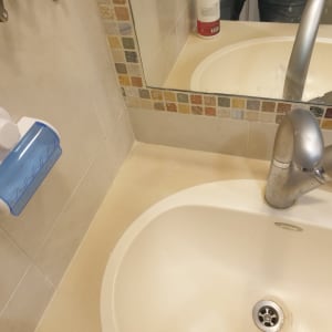 כיור עם ברז כסוף ומתקן סבון כחול