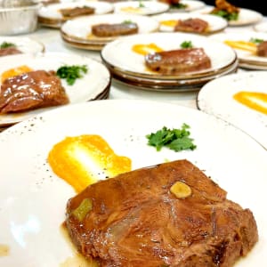 מנות בשר עם רוטב כתום וקישוט פטרוזיליה