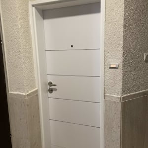 דלת לבנה עם ידית כסופה ומנעול