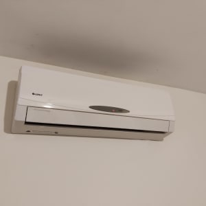 מזגן קיר לבן מותקן על קיר לבן