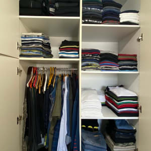 ארון בגדים מסודר עם בגדים מקופלים ותלויים