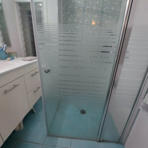 מקלחון עם דלת זכוכית ודוגמת אריחים עגולה