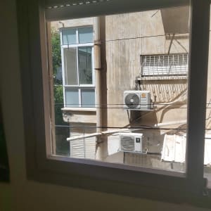 חלון זכוכית עם מסגרת לבנה בבניין סמוך