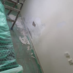 קיר עם קילופי צבע, סולם וכיסוי רצפה