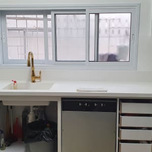 מטבח עם משטח שיש לבן וכיור מובנה