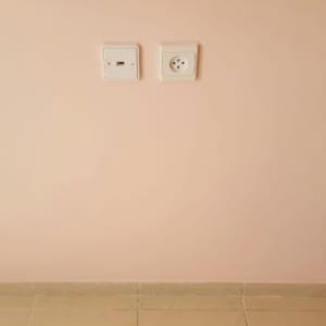 קיר צבוע בצבע ורוד בהיר עם שקעי חשמל