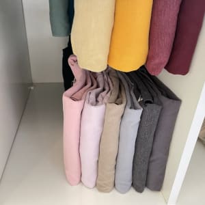 בגדים מקופלים ומסודרים בארון בצבעים שונים