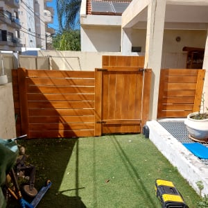 גדר עץ חומה עם שער בגינה קטנה