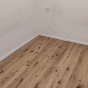 רצפה עץ נקייה עם קיר לבן