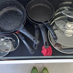 סירים ומחבתות מאורגנים במגירה עם מכסים