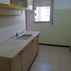 מטבח עם ארונות עץ, כיור וברז, קיר אריחים