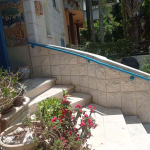 מעקה כחול על קיר אבן ליד מדרגות