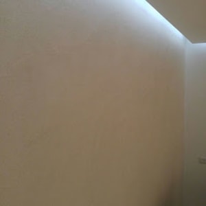 קיר צבוע בלבן עם תאורה עליונה