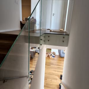 מעקה זכוכית שקוף במדרגות עץ בבית מודרני