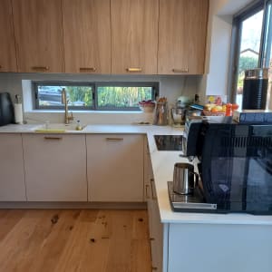 מטבח מאורגן עם ארונות עץ, מכונת קפה וכלים על השיש