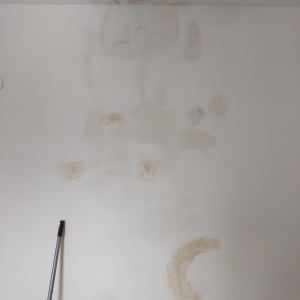 קיר עם תיקוני צבע ומוט צביעה