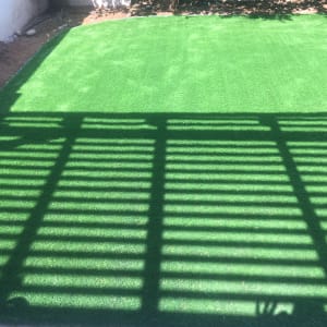 דשא סינתטי עם צל של פרגולה