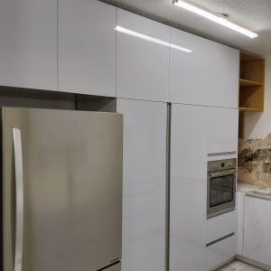 מטבח עם מקרר, תנור וארונות לבנים