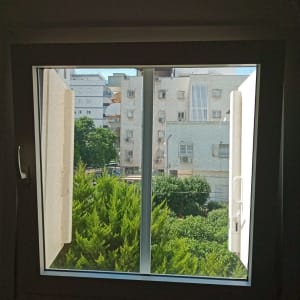 חלון אלומיניום פתוח עם ידיות לבנות
