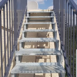 מדרגות מתכת עם מעקות בצדדים בשמיים כחולים