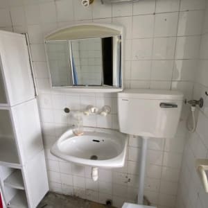 חדר אמבטיה עם כיור, ארון וכלים לניקוי