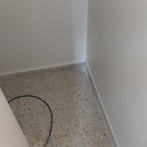 קיר צבוע בלבן עם רצפת טרצו