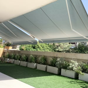 סוככים אפורים נמתחים מעל גינה ירוקה