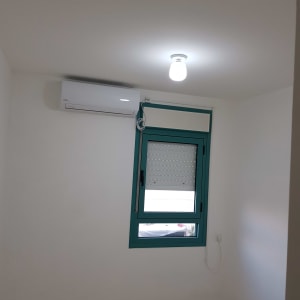 נורה דולקת ותיבת מיזוג אוויר על הקיר