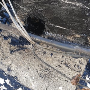 חומר איטום שחור על גג עם כבלים