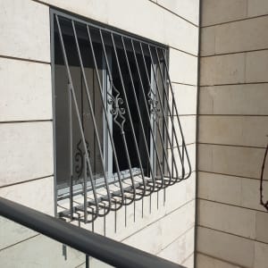 סורגי מתכת מעוצבים על חלון קיר חיצוני