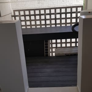 רצפת עץ חדשה במרפסת עם מעקה רשת