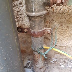 צינור מתכת עם חוטי חשמל ירוקים וצהובים